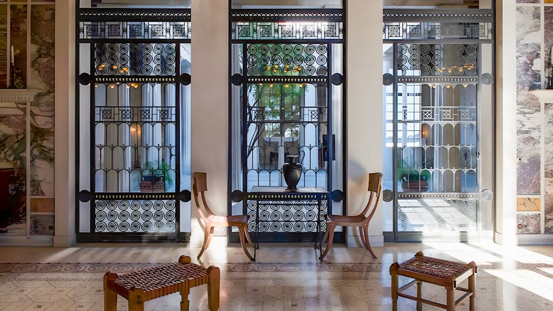 Elegant interior of Villa Kerylos with decorative ironwork and wooden furniture.