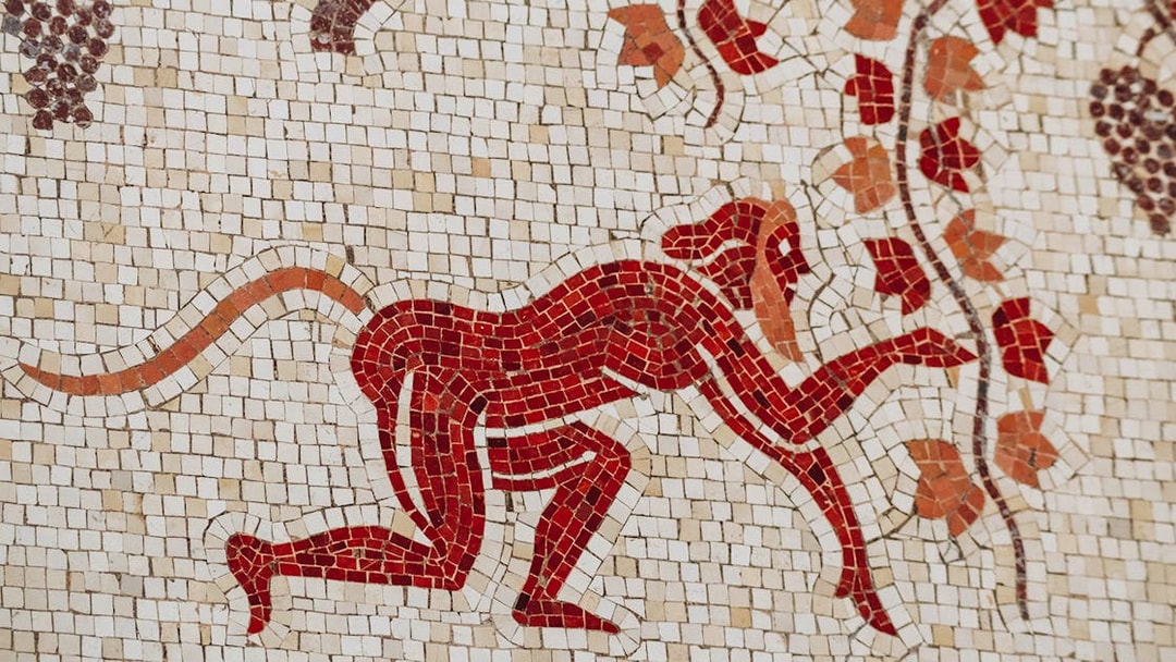 Mosaic of a red monkey with vines at Villa Kerylos, France.