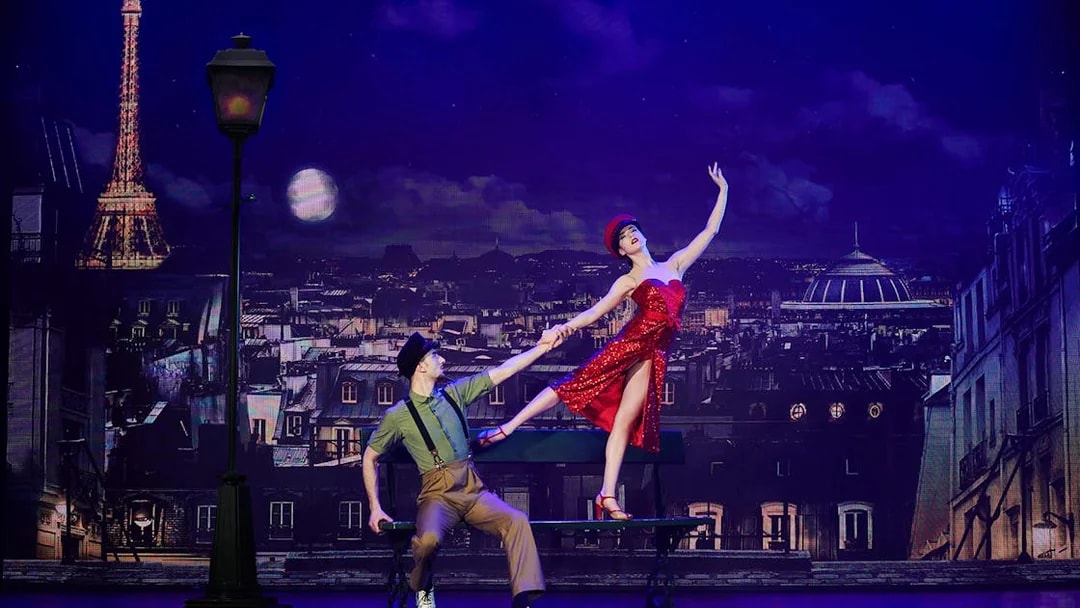 Dancers performing at Paradis Latin show in Paris with Eiffel Tower backdrop.