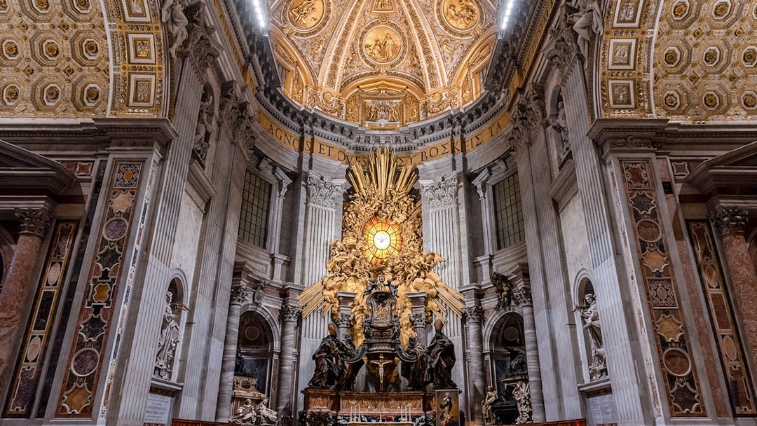 Altar of St. Peter's Basilica with ornate ceiling and sculptures, Vatican City.