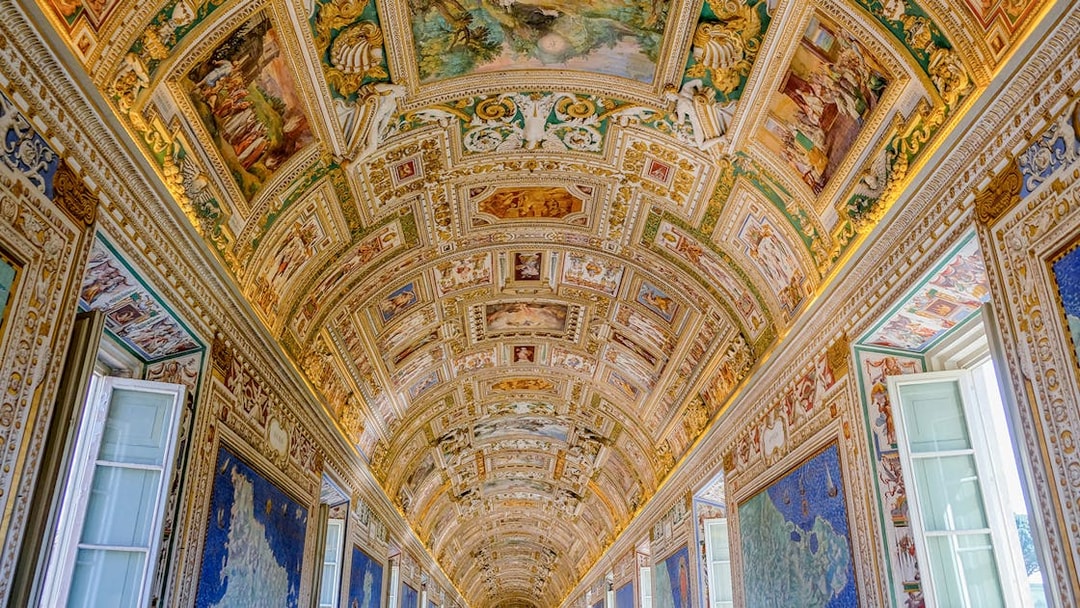 Vatican Museums' ornate hallway ceiling with detailed frescoes and maps.