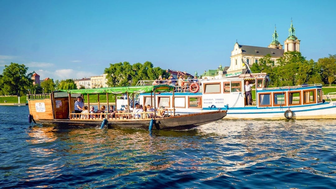 Vistula river cruise boat near the Church on the Rock in Krakow, Poland.