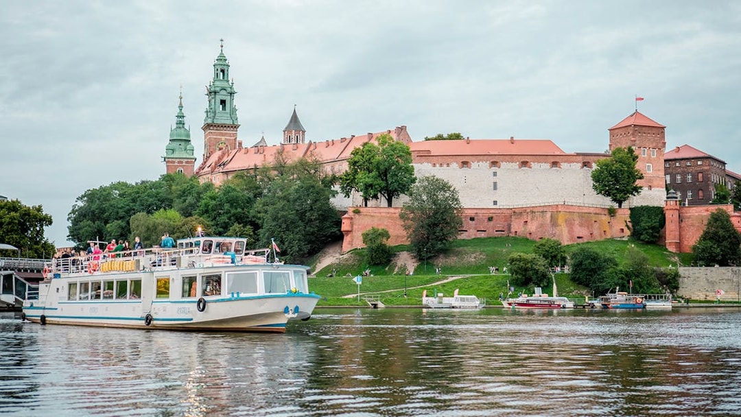 Sightseeing boat on Vistula River with Wawel Castle in Krakow in the background.