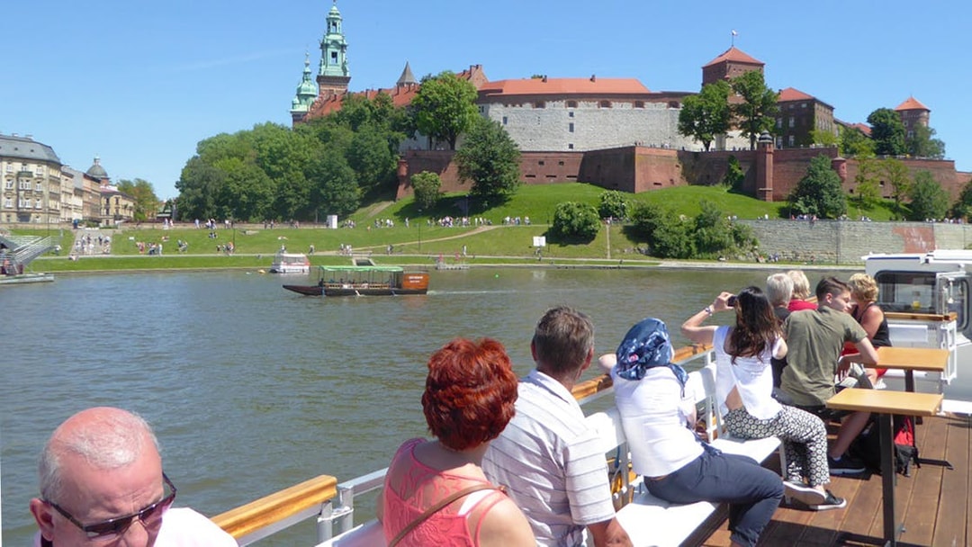 Tourists on a Vistula River cruise viewing Wawel Castle in Krakow.