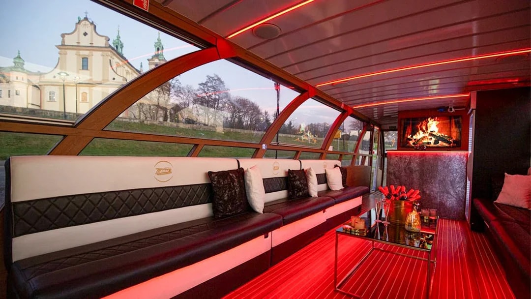 Interior of the Vistula River Cruise catamaran in Krakow with seating and a view of a church.