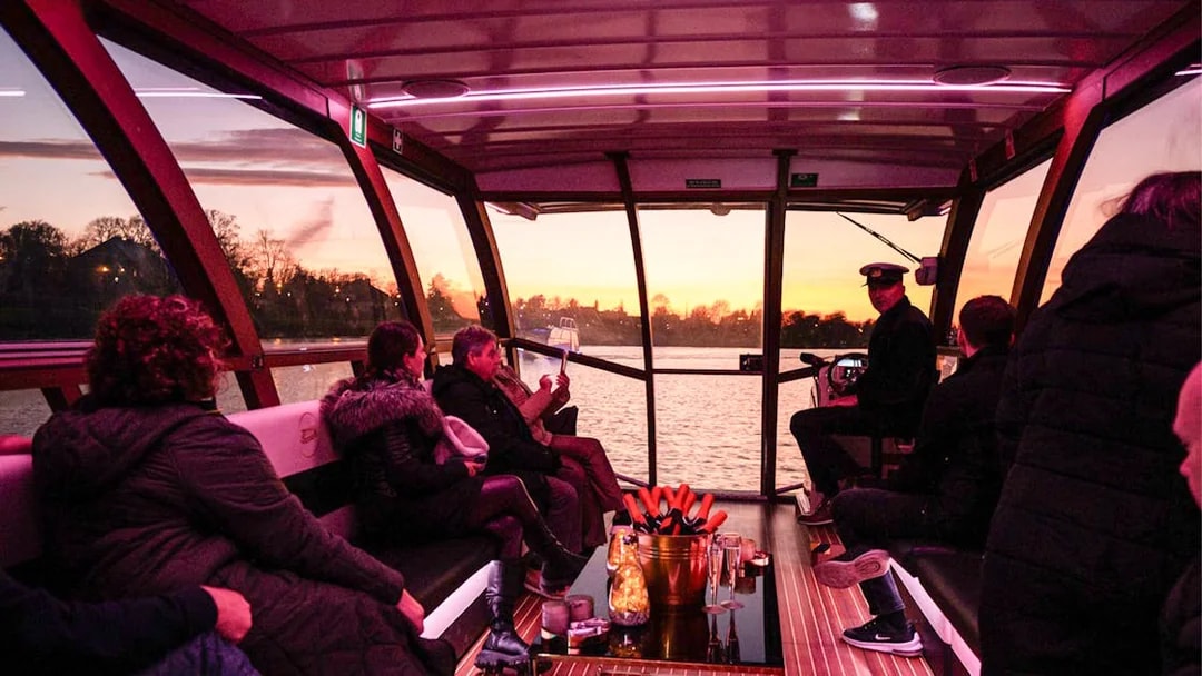 Cruise passengers enjoy sunset views on a Vistula River catamaran in Krakow.