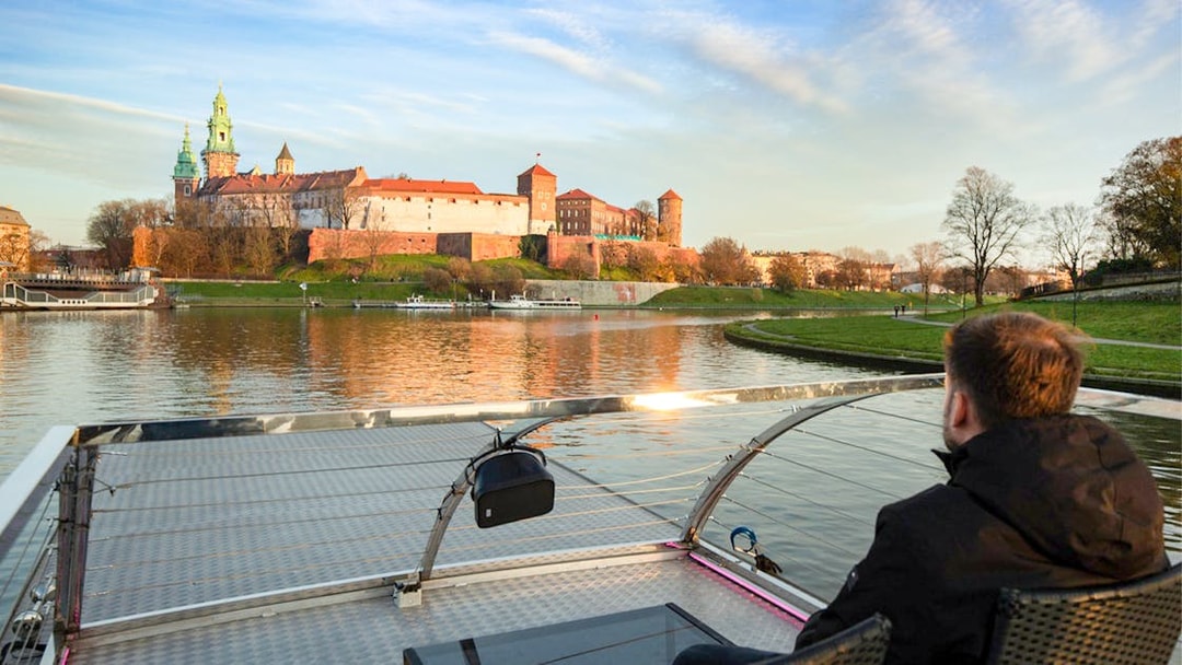 Guest viewing Wawel Castle from a catamaran on Vistula River Cruise, Krakow.