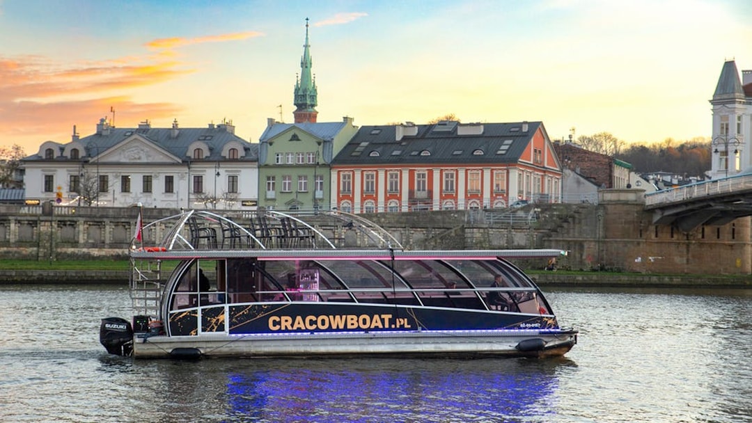 Catamaran with lights on Vistula River during Krakow evening cruise.