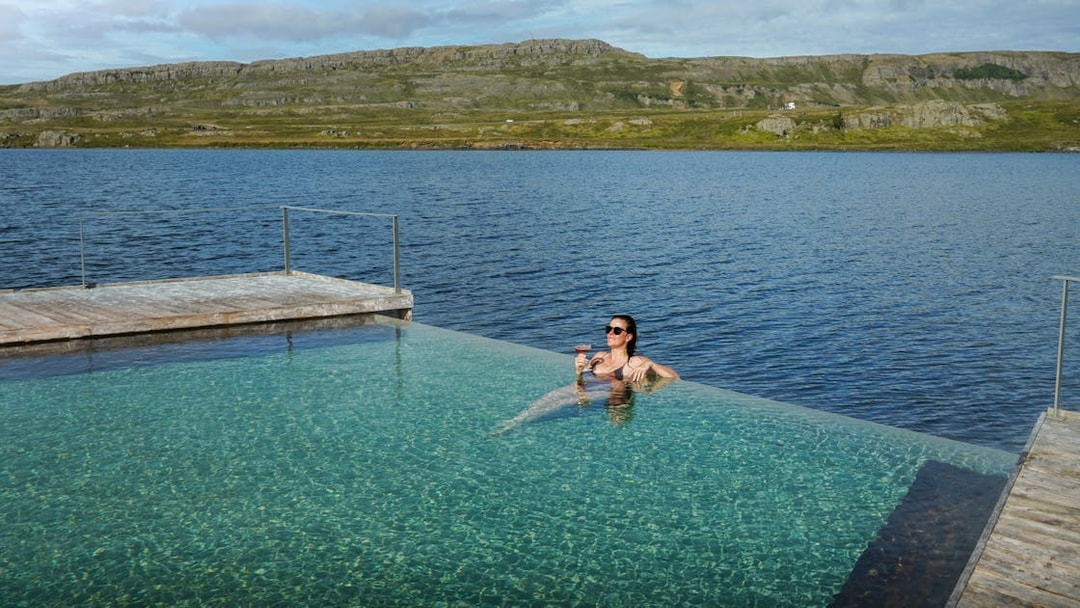 Person relaxing in Vök Baths infinity pool overlooking Lake Urriðavatn, Egilsstaðir.