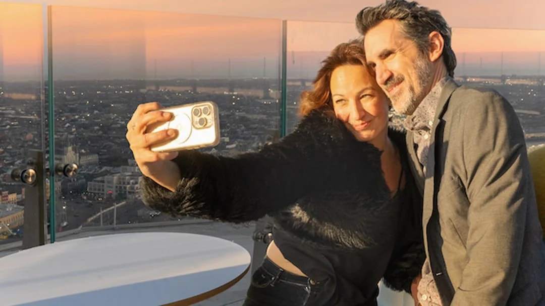 Couple taking a selfie at Vue Orleans Observation Deck during sunset.