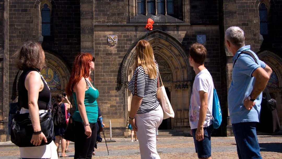 Tourists exploring Vyšehrad Castle's historic entrance in Prague.