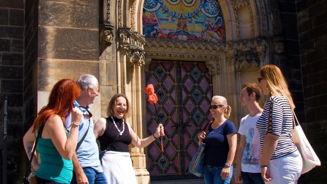 Tour group at Vyšehrad Castle entrance, Prague, with guide holding a flag.