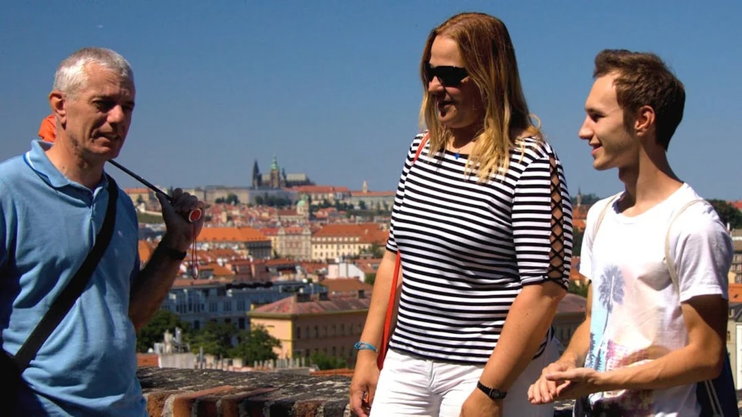 Tourists at Vyšehrad Castle with Prague cityscape in the background.
