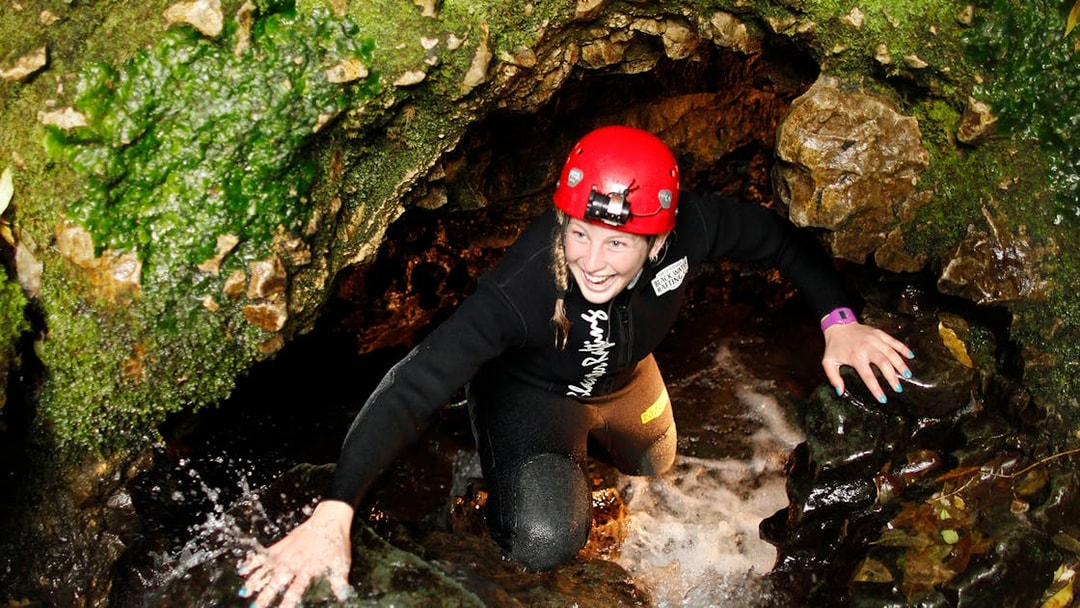 Adventurer exploring Waitomo cave during Black Water Rafting tour.