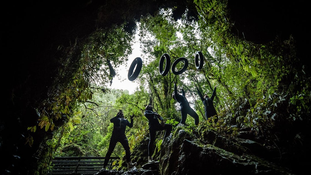 Adventurers in wetsuits prepare for black water rafting in Waitomo cave.