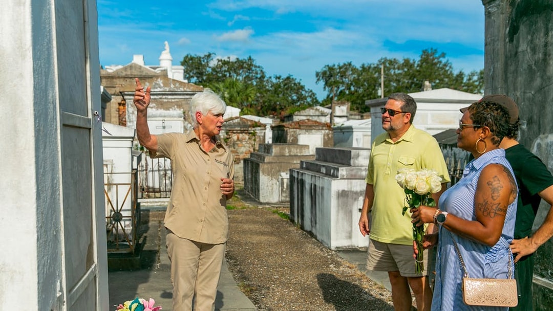 Tour guide explaining tombs to guests in St. Louis Cemetery, New Orleans.