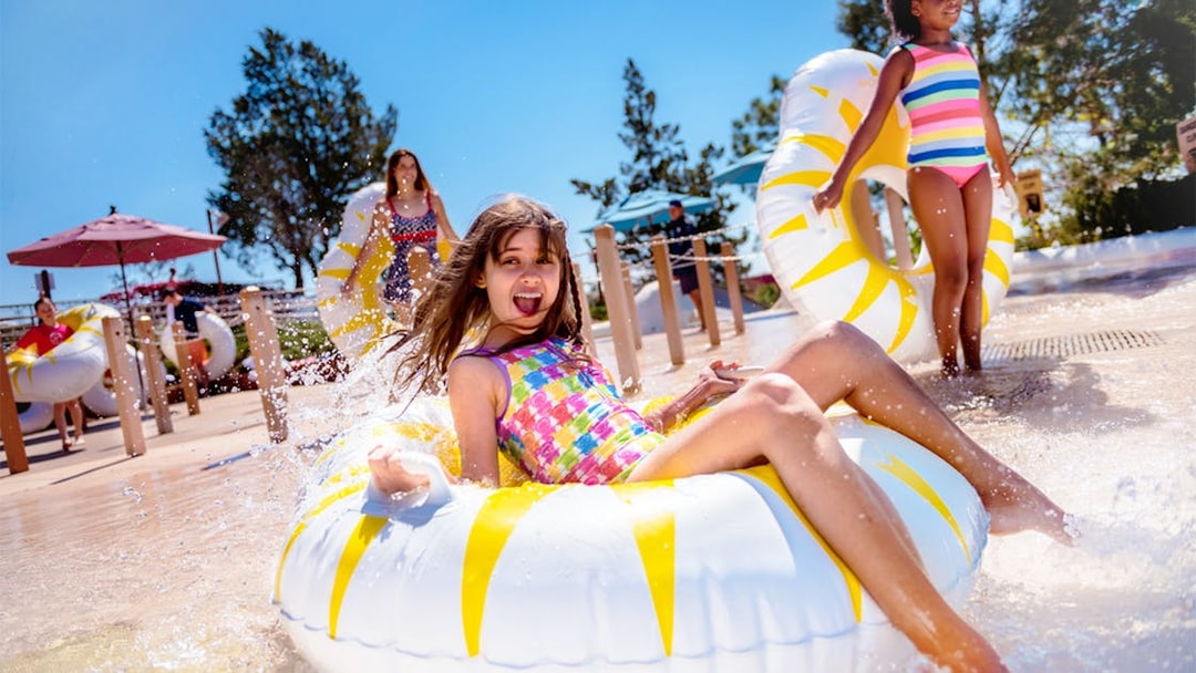 Girl enjoying water slide on tube at Walt Disney World Resort, Orlando.