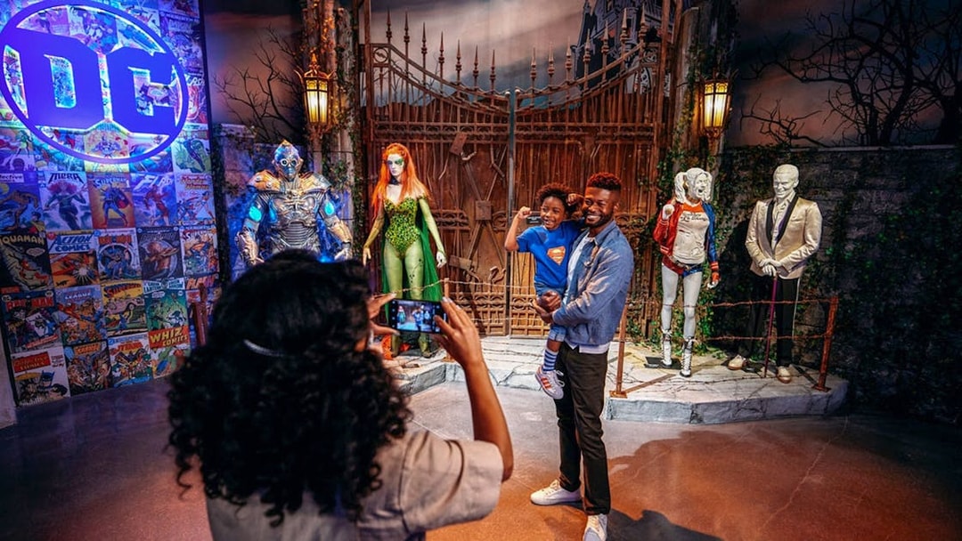 Tourist photographing family near DC exhibit at Warner Bros. Studio.