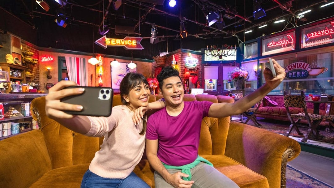 Tourists taking a selfie on the Friends set at Warner Bros. Studio.
