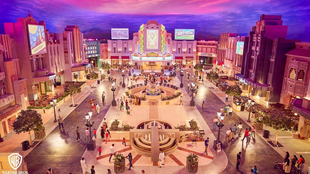 Warner Bros. World™ Abu Dhabi plaza with visitors and vibrant architecture.