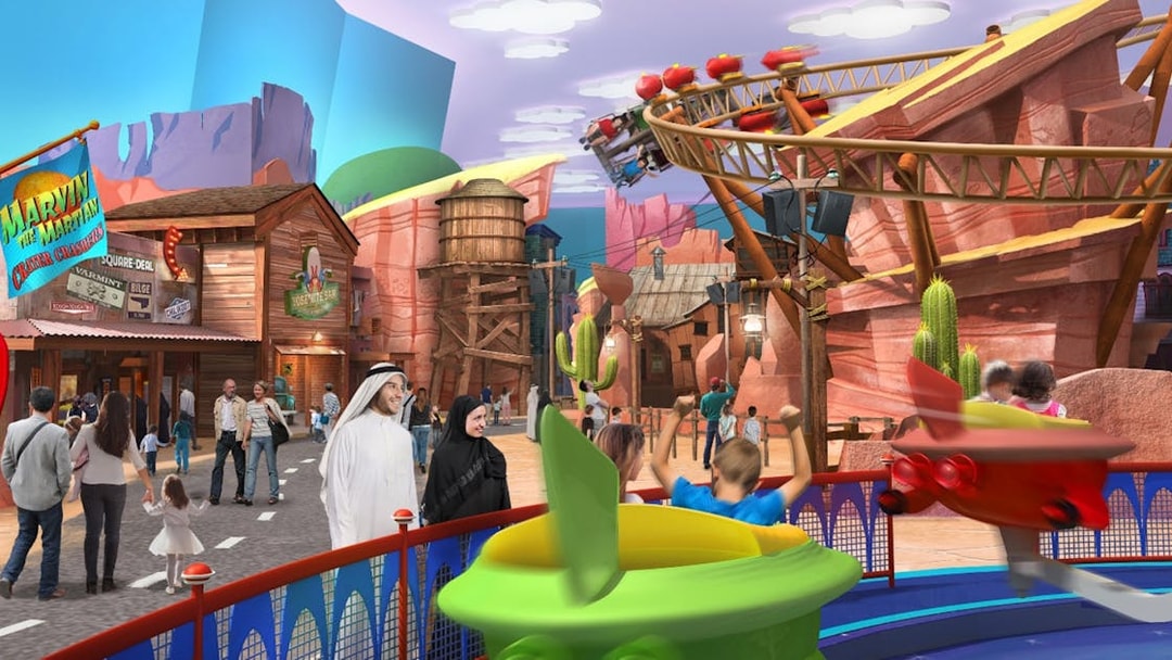 Warner Bros World Abu Dhabi theme park with families enjoying rides and attractions.