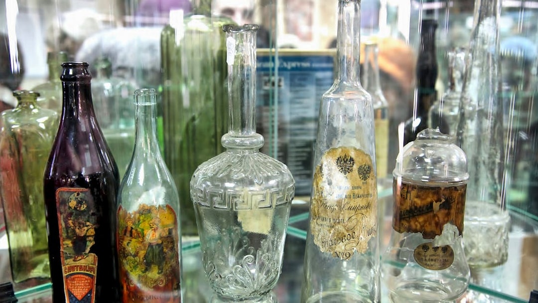 Antique glass bottles displayed in a Warsaw museum exhibit.