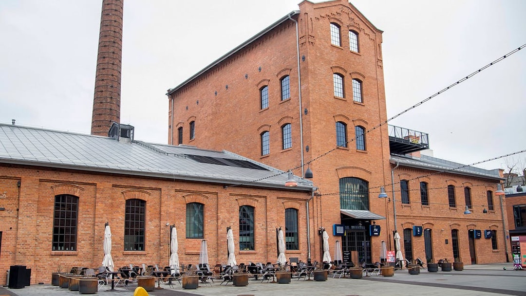 Historic brick building with outdoor seating in Warsaw, Poland.