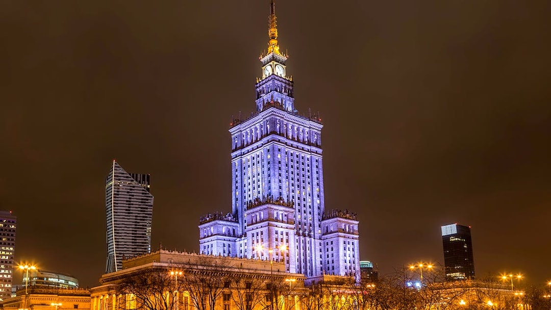 Palace of Culture and Science illuminated at night in Warsaw, Poland.