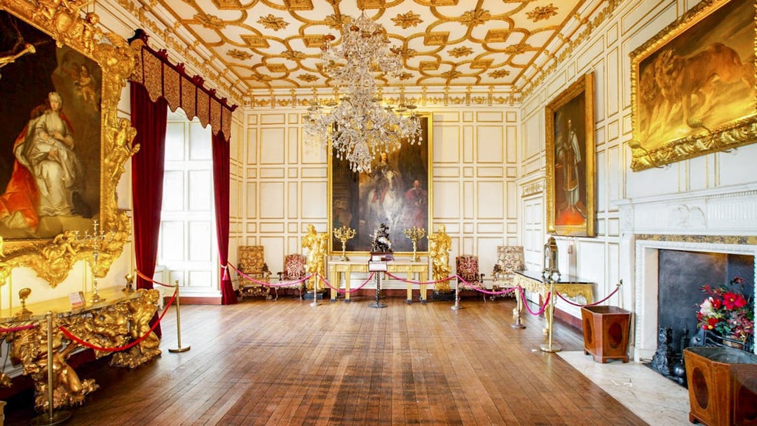 Warwick Castle interior with ornate paintings and chandelier.