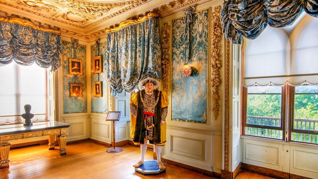 Warwick Castle interior with historical figure statue and ornate decor.