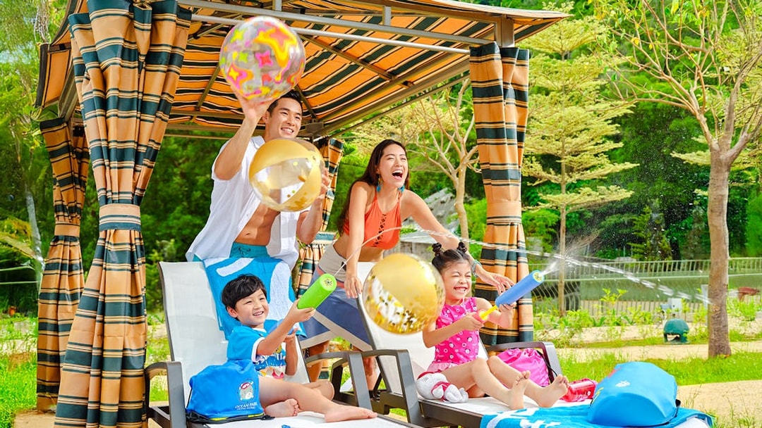 Family playing with water toys by the pool at Water World Ocean Park, Hong Kong.