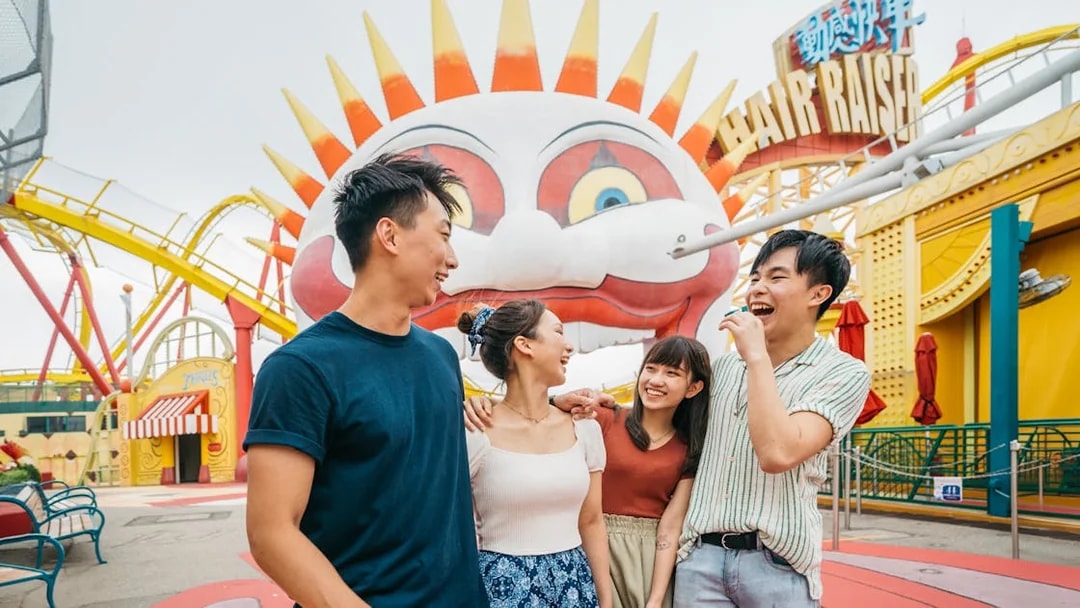 Friends laughing near the Hair Raiser ride at Ocean Park Theme Park.