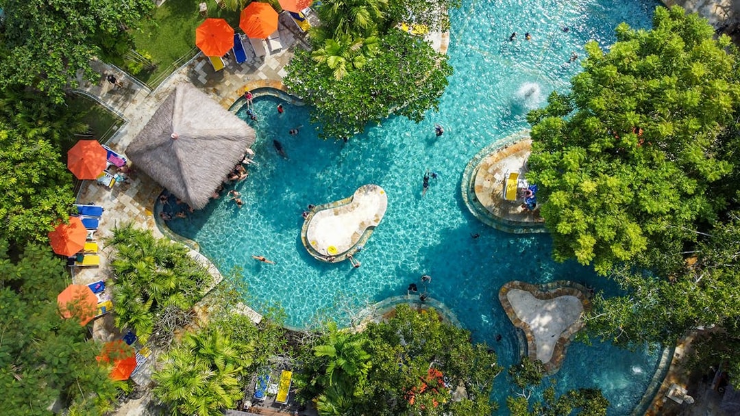 Aerial view of the Pleasure Pool at Waterbom Bali with sun loungers and umbrellas.