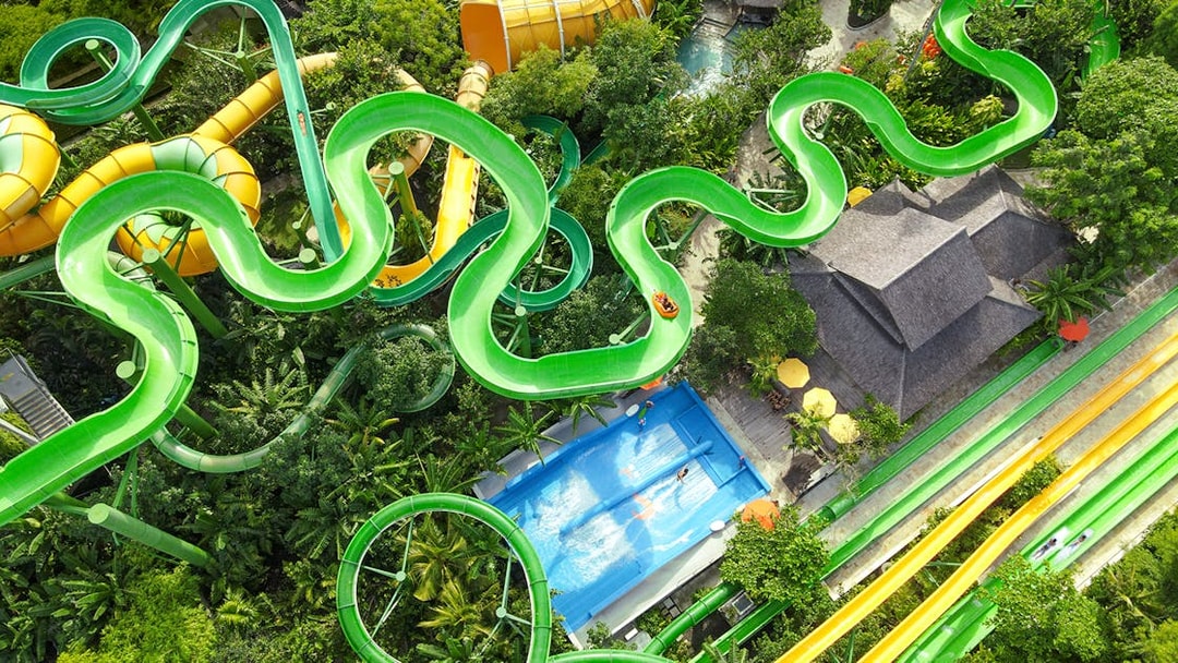 Aerial view of the Constrictor water slide at Waterbom Bali, surrounded by lush greenery.
