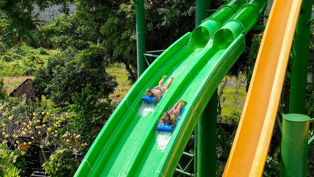 Two girls sliding down Twin Racers waterslide at Waterbom Bali.
