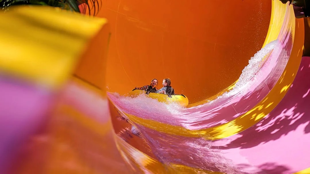 Two girls on a water tube sliding down the Python waterslide at Waterbom Bali.
