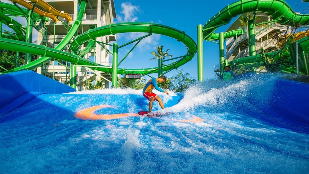 Boy surfing on Flow Rider at Waterbom Bali water park, Indonesia.