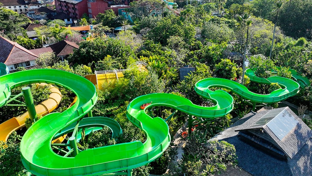 Waterbom Bali green water slide winding through lush tropical landscape.