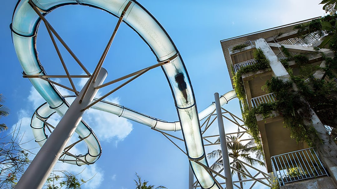Water slide at Waterbom Bali with lush greenery and clear sky.