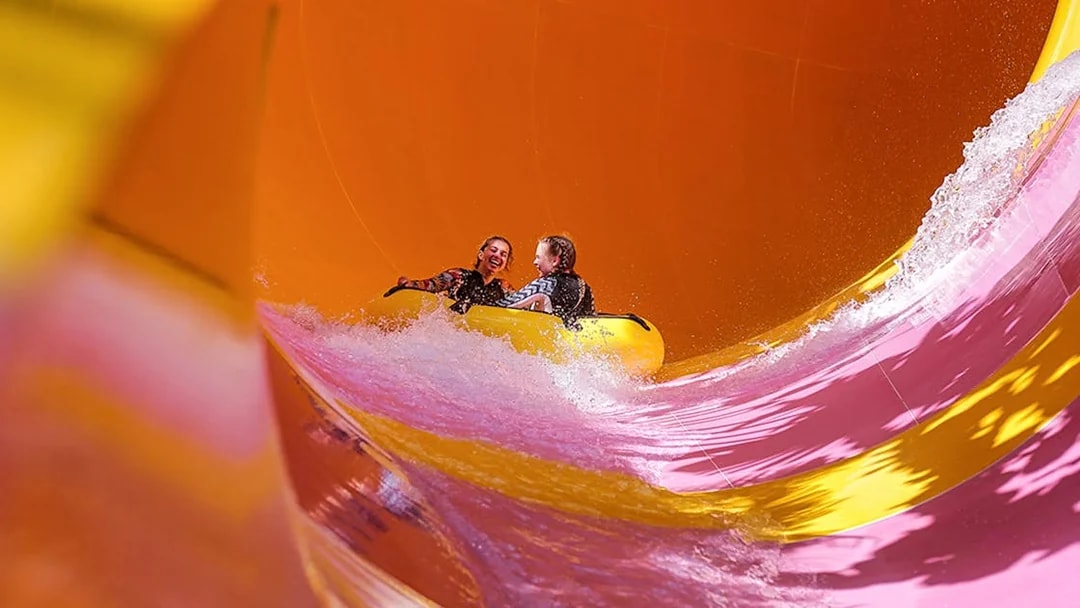 Two girls on a water tube sliding down the Python waterslide at Waterbom Bali.