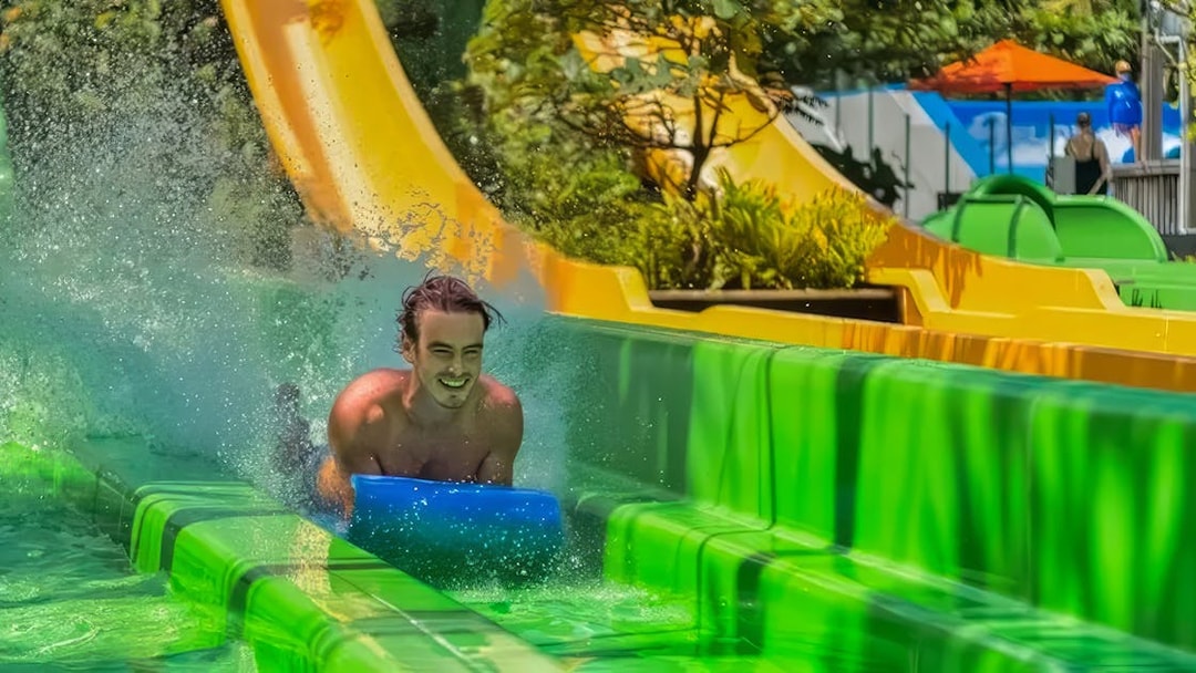 Man sliding down a water slide at Waterbom Bali, Indonesia.
