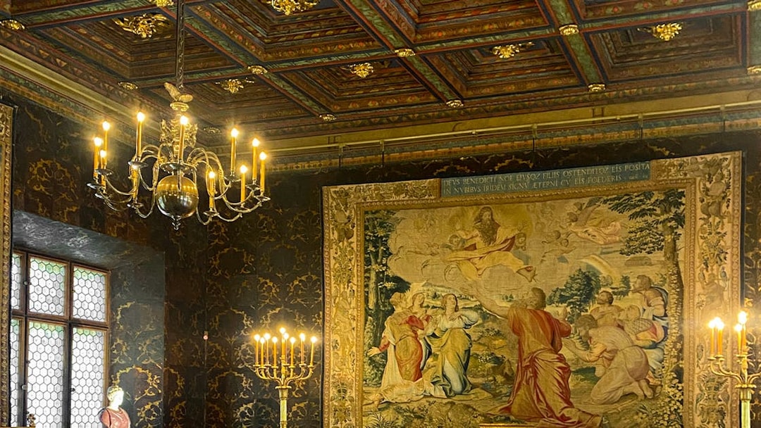 Wawel Castle interior with ornate tapestry and chandelier, Krakow tour.