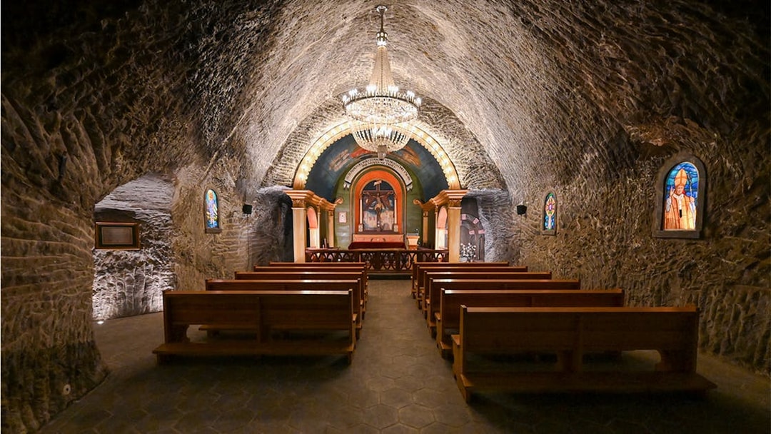 Underground church interior at Wieliczka Salt Mine with altar and chandeliers.