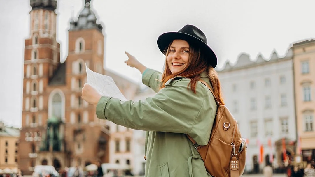 Traveler pointing at St. Mary’s Basilica in Krakow's Old Town during guided tour.