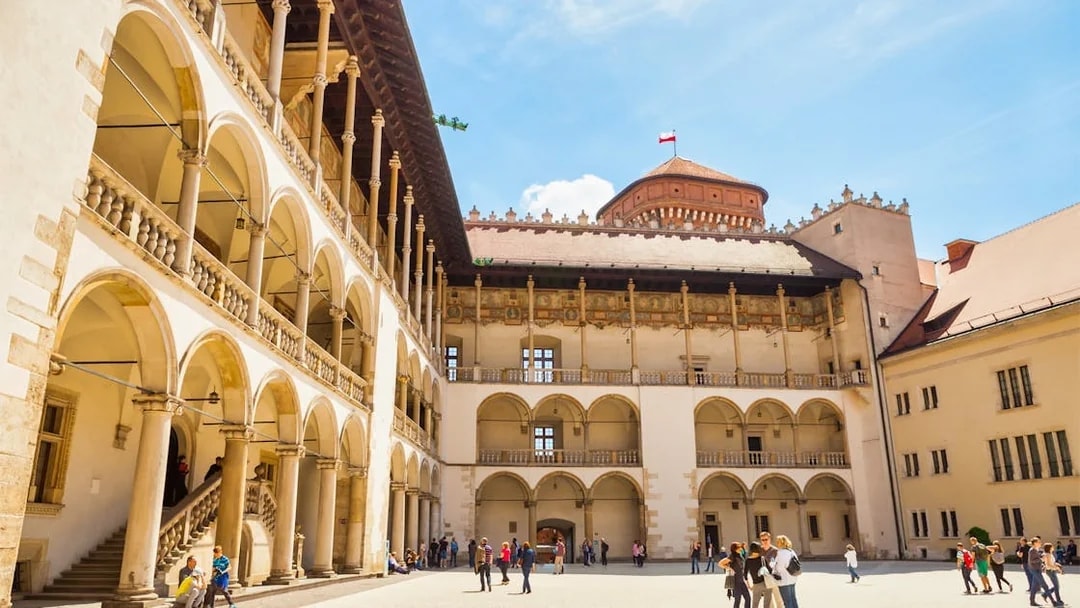 Wawel Royal Castle courtyard with tourists on a guided tour in Krakow, Poland.