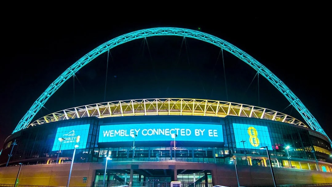 Wembley Stadium illuminated at night, showcasing the iconic arch in London.
