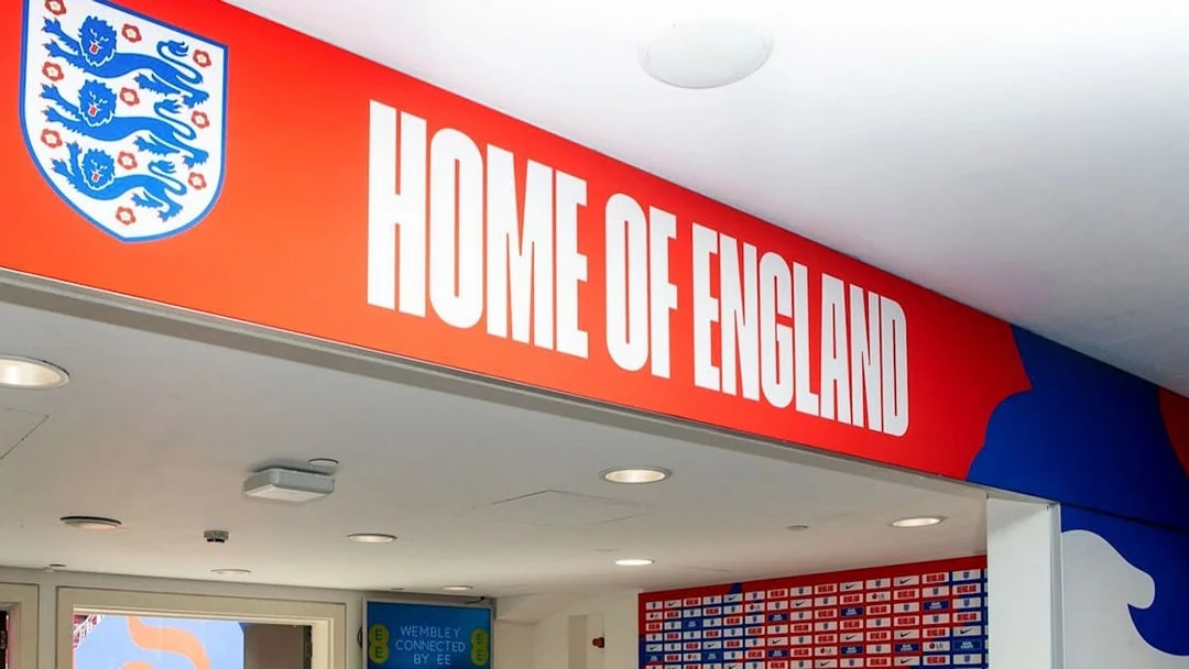 Player tunnel entrance at Wembley Stadium with "Home of England" sign.