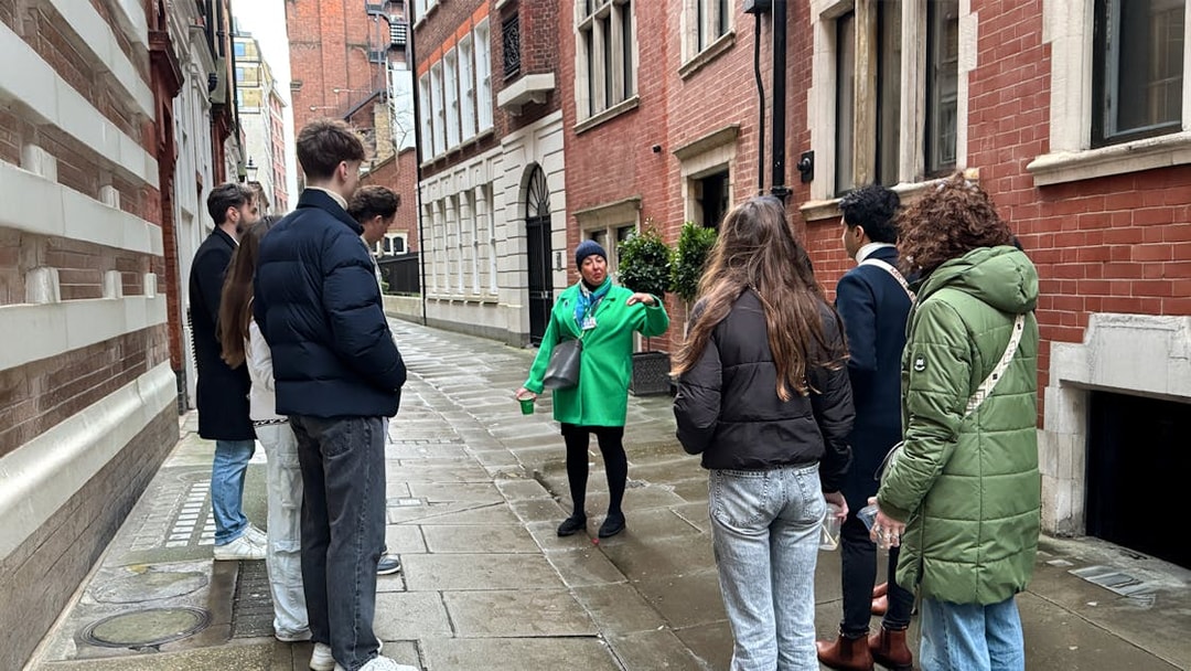 Tour guide leading a group through a historic London street near Westminster Abbey.
