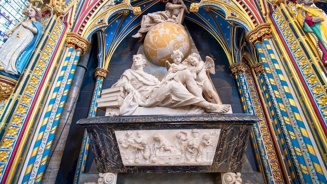 Marble monument inside Westminster Abbey with colorful arches and detailed sculptures.