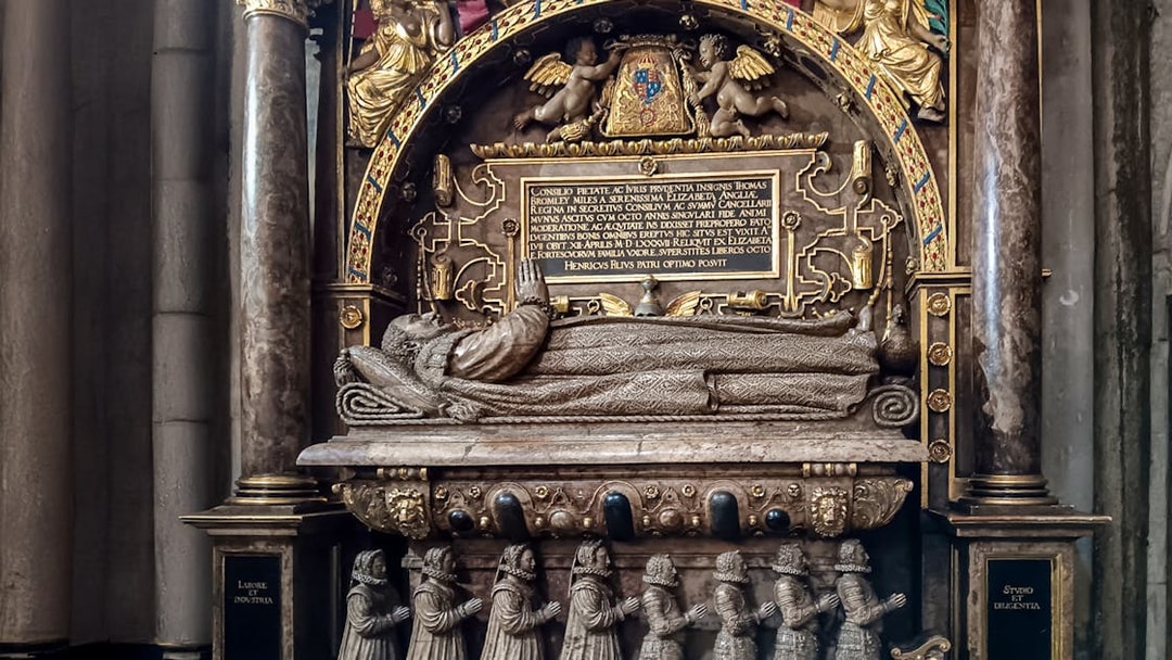 Tomb monument inside Westminster Abbey, featuring intricate carvings and Latin inscriptions.